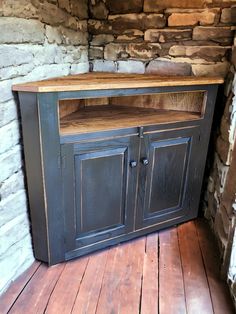 an old fashioned entertainment center in a stone walled room with wood flooring and brick walls