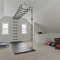 a room with white walls and an attic style ceiling has a yoga mat on the floor