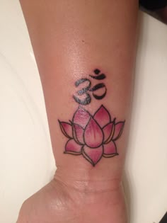 a lotus flower tattoo on the wrist with omen symbol in it's center