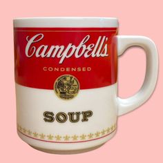 a coffee mug with campbell's soup on the front and sides, against a pink background