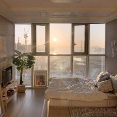 a bedroom with large windows and a bed in front of a window that looks out onto the ocean