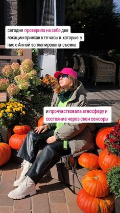 a woman is sitting on a bench with pumpkins in the background and another sign above her