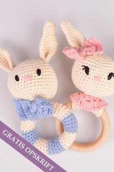 two crocheted stuffed animals holding on to a wooden ring