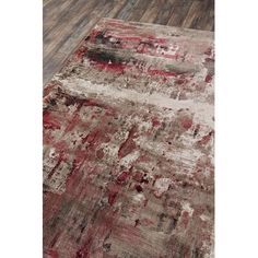 an area rug with red and grey colors on the floor in front of a wooden floor