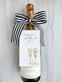 a bottle of wine with a ribbon around it and a card attached to the top