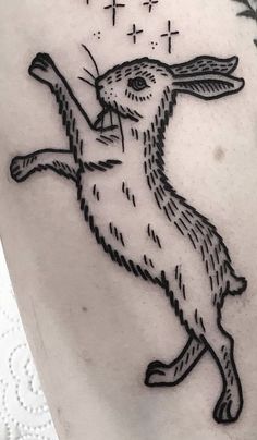 a black and white tattoo of a rabbit