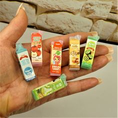 a person is holding small miniature toothpaste tubes in their hand and there are several different flavors on them