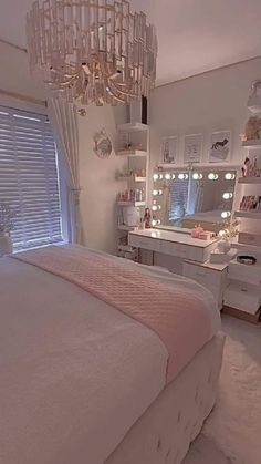 a bedroom with a chandelier hanging from the ceiling and a white bed in front of a window