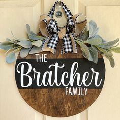 a wooden sign that says the bracher family hanging on a door with greenery