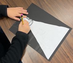 a child is drawing on a piece of paper