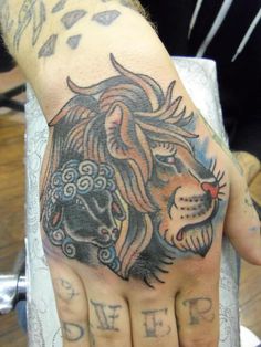 a hand with a lion tattoo on it