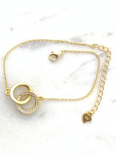 "✦DESCRIPTION ✦ Symbolizing the eternal bond of love, this 14kt yellow gold plated Sterling silver bracelet joins two interlocking open circles. Polished finish. Stationed on a cable chain. Spring ring clasp - Chain bracelet measurement is 7\" inch plus the 2\" inch extension. ✦Dear Customers ✦ We strive to provide the best quality with affordable prices. We take such pride in making sure to create unique, beautiful jewelry for all our Sioro Silver customers, and always seek to provide the very Elegant Chain Bracelet For Anniversary And Mother's Day, Delicate Gold Chain Bracelet With Cubic Zirconia, Elegant Gold Bracelets For Valentine's Day, Adjustable Gold-plated Bracelet For Anniversary, Adjustable Gold Plated Bracelet For Anniversary, Gold Bracelet With Delicate Chain For Valentine's Day, Gold Plated Bracelets For Anniversary On Mother's Day, Gold Plated Bracelets For Mother's Day Anniversary, Gold Promise Bracelet For Valentine's Day