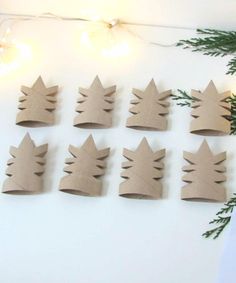 paper crowns are arranged on the wall next to christmas lights and greenery, as well as pine branches