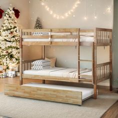 a bunk bed sitting next to a christmas tree in a room with lights on the ceiling