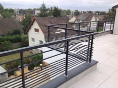 a balcony with metal railings and houses in the background