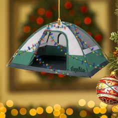 a tent ornament hanging from a christmas tree