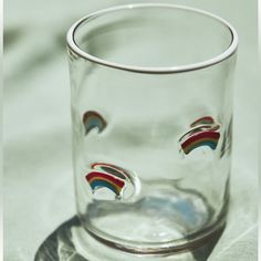 a shot glass with rainbows painted on the bottom and inside is sitting on a table