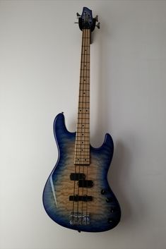 an electric bass guitar hanging on the wall