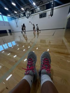 a person's feet with pink laces on a basketball court