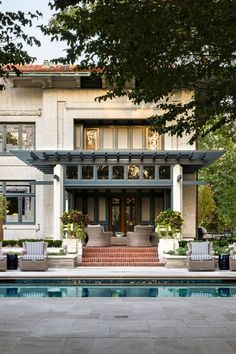 a house with a pool in front of it and lots of windows on the side