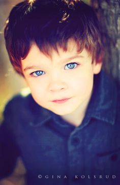 a young boy with blue eyes looking at the camera