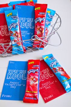 several packets of toothpaste sitting in a wire basket next to each other on a table