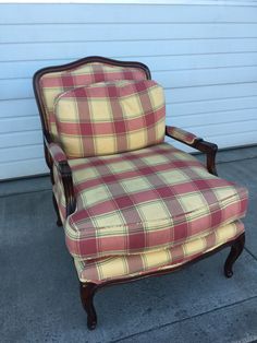 an old chair sitting on the sidewalk in front of a garage door