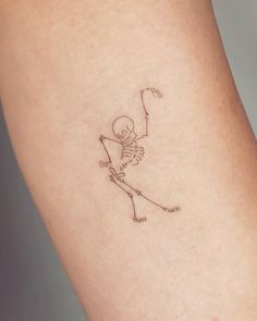 a skeleton with a bow and arrow tattoo on the side of her leg, holding a string