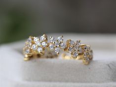 two yellow gold rings with small diamonds on them sitting on a white piece of cloth