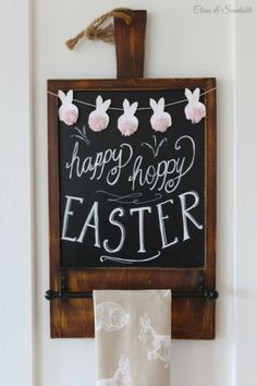 a sign that says happy hoppy easter hangs on the wall next to a towel rack