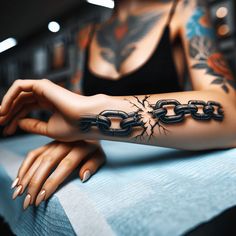 a woman with tattoos on her arm is sitting at a table and has chains attached to it