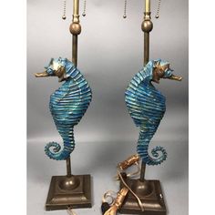 two blue seahorses are standing next to each other on a stand with gold accents