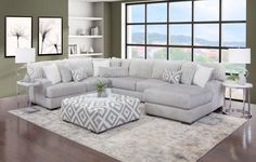 a living room scene with focus on the sectional sofa and footstool in the center