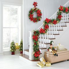 christmas decorations on the banisters and stairs in a house with presents under them