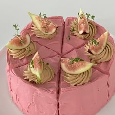 a cake with pink frosting and figs on top