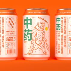 three cans of beer with chinese writing on the front and back, against an orange background