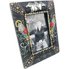 a black and white photo frame with an animal on it's side, decorated with gold accents