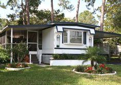 a white and black house with trees in the background