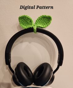 headphones with green leaves on them are sitting next to a sign that says digital pattern