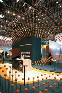 an exhibit with orange balls hanging from the ceiling