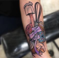 a woman's arm with an assortment of doughnuts and pastry items on it