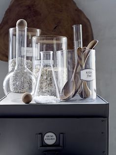 some glass beakers are sitting on top of a cabinet with magnets in them