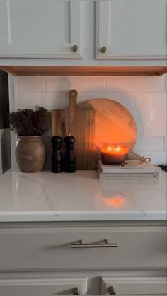 a kitchen counter with some candles on top of it and other items sitting on the counter