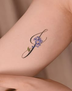 a woman's arm with a flower tattoo on the left side of her arm