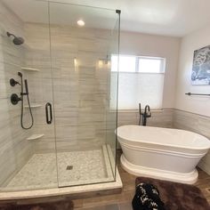 a bathroom with a bathtub, shower and rugs on the floor in front of it