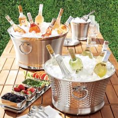 an ice bucket filled with bottles of wine on top of a wooden table