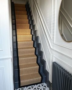 a staircase with carpeted steps leading up to a mirror on the wall above it