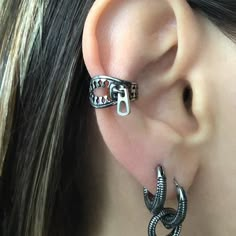 a close up of a person's ear with two different types of earrings on it