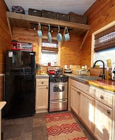 a kitchen with wood paneling and stainless steel stove top oven, dishwasher, microwave and refrigerator