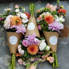 a bunch of flowers that are sitting in some kind of cone shaped planter on the ground